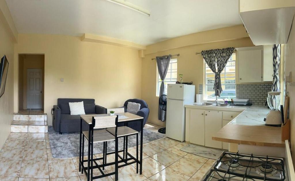 a kitchen and living room with a couch and a table at Hibiscus Apt 1 in Corinthe