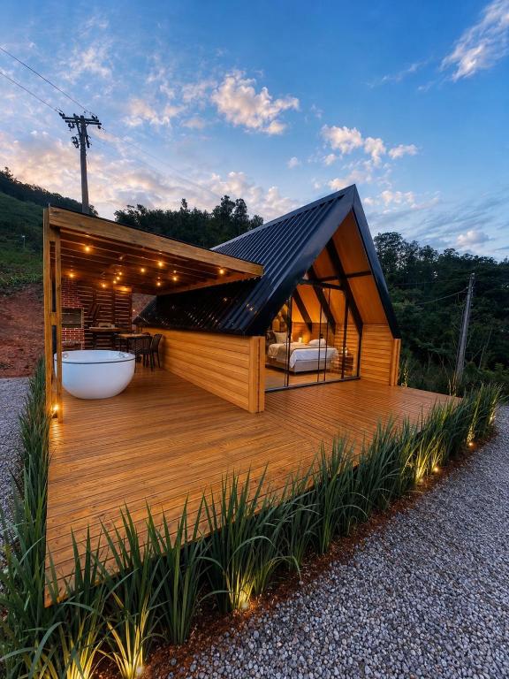 a small building with a deck with a bath tub at Cabana Do Luar in Serra Negra