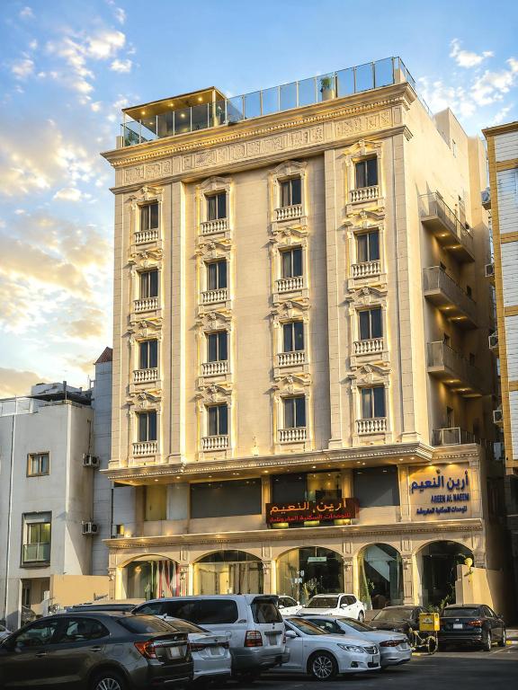 a large white building with cars parked in front of it at Areen Al Naeem Served Apartments in Jeddah