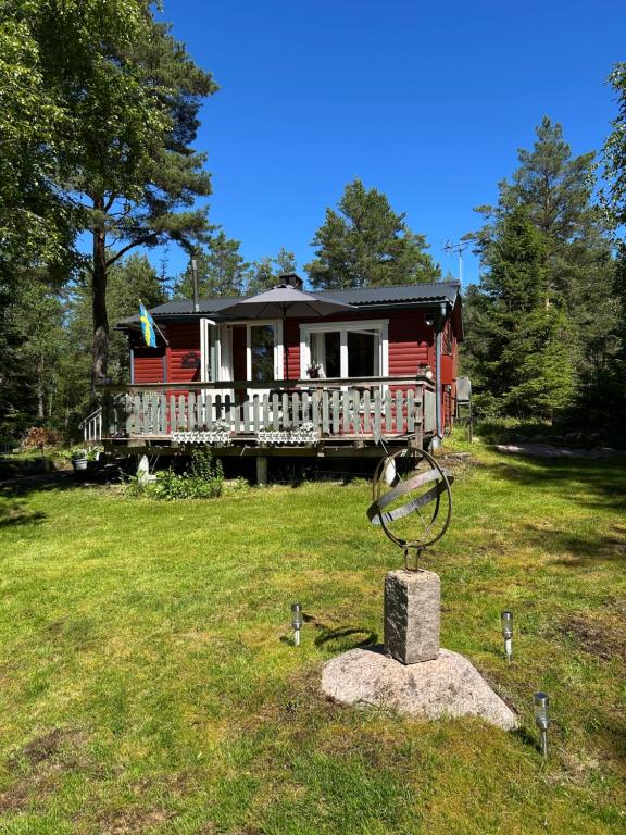 a red house with a statue in front of it at The Hunters Hill - Cosy private forest retreat in Brålanda