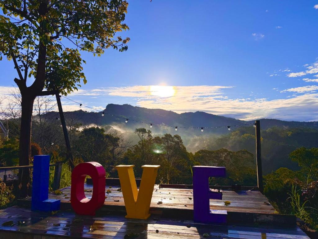 a sign that says love with a view of the mountains at Fong Chou Chalet in Sanyi