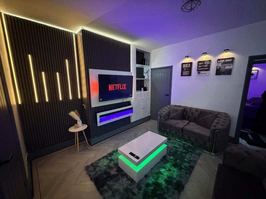 a living room with a couch and a tv at GS Maisons Hideaway in Sheffield