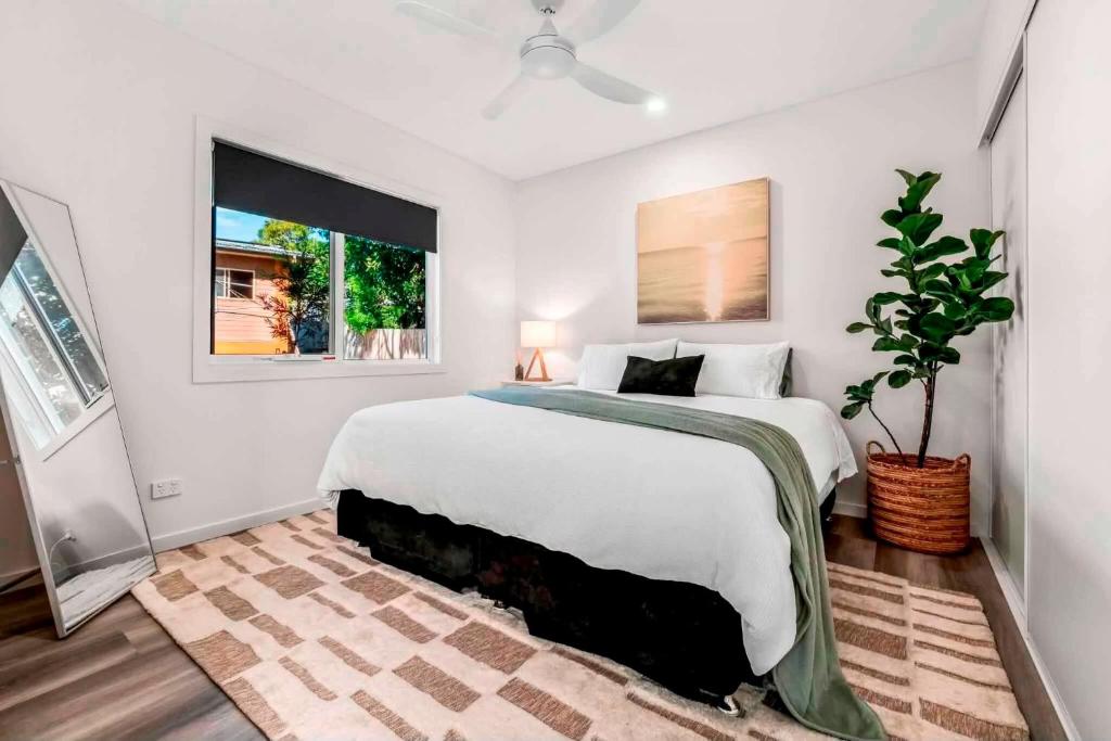 a white bedroom with a large bed and a window at Private Modern Bungalow - Separate Entry in Brisbane