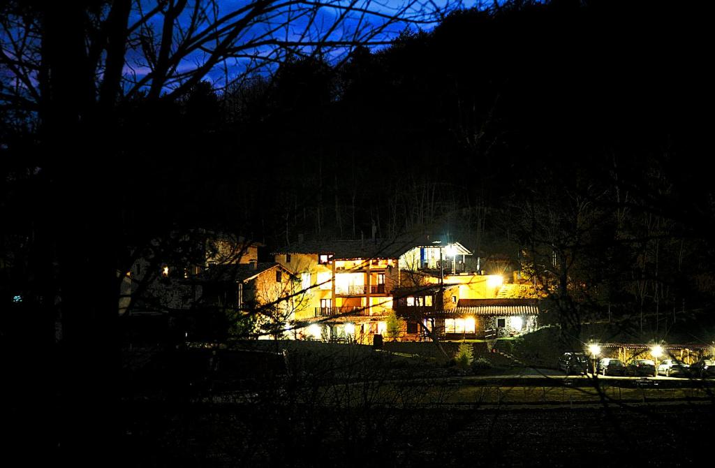 una casa iluminada por la noche con luces en Casa Rural El Reixac, en Sant Joan de les Abadesses