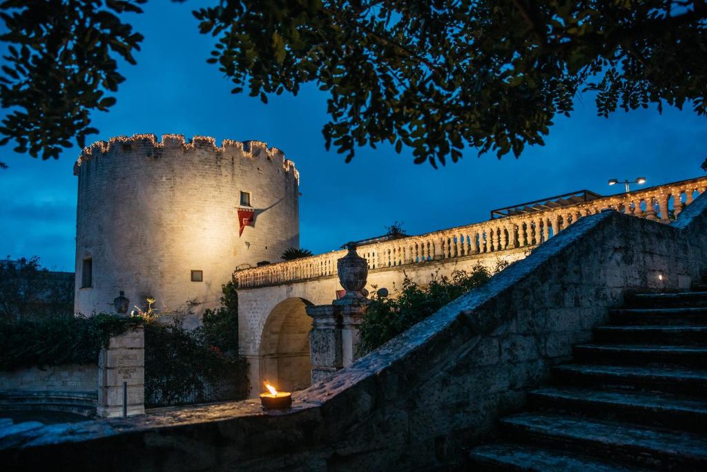 a castle with a candle on a wall at night at Dimora Storica Torre Del Parco 1419 in Lecce
