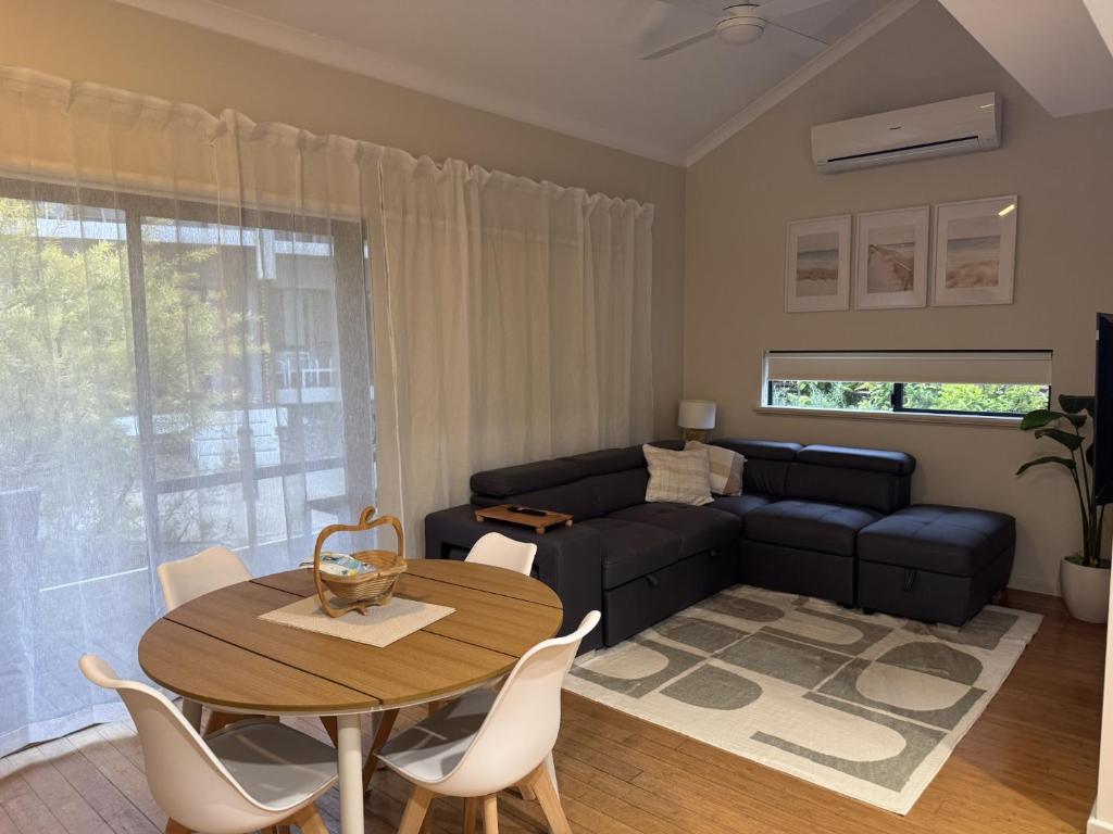 a living room with a table and a couch at Sea Renity Preston Beach in Preston Beach