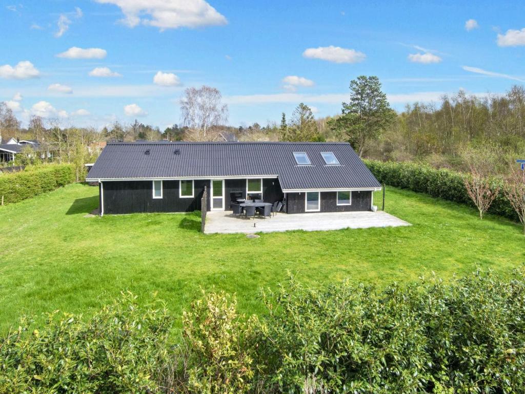 a small black house with a large yard at 4 star holiday home in Ørsted-By Traum in Ørsted