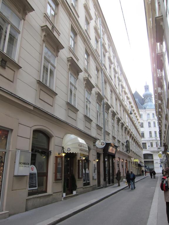 a street with buildings and people walking down the street at Apartment Altwien in Vienna