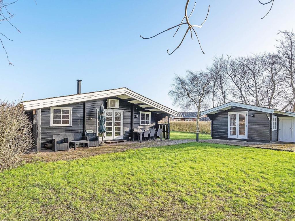 a small black house with a yard at 4 star holiday home in Hemmet in Hemmet