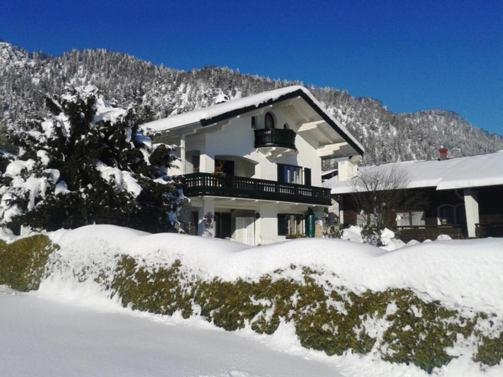une maison avec de la neige devant elle dans l'établissement Landhaus Bellecôte, à Reit im Winkl