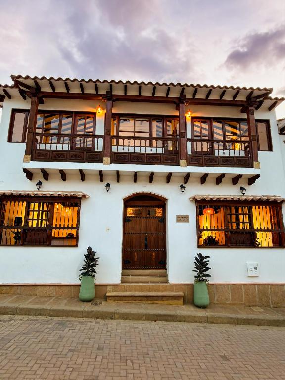 a white building with wooden doors and windows at Yeshca Hotel Boutique in Villa de Leyva