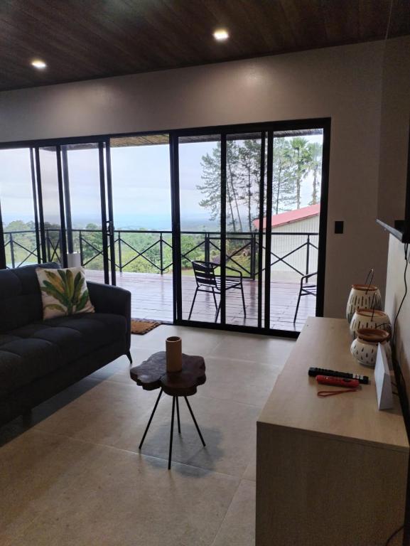 a living room with a couch and a table at La Cima Escondida Bijagua Rio Celeste 20 Min in Upala