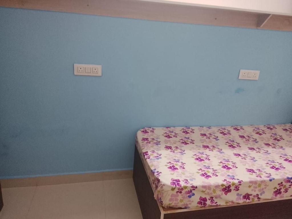 a bedroom with a bed with flowers on it at Pemmis living space in Bangalore