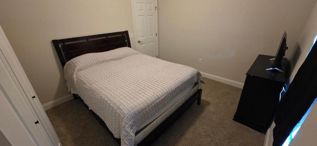 a small bedroom with a bed and a black dresser at Room in Downtown Orlando! Close to everything! in Orlando