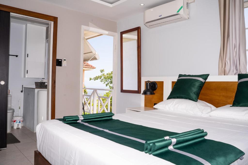 a bedroom with a large white bed with green accents at Kingston Horizon Retreat in Kingston