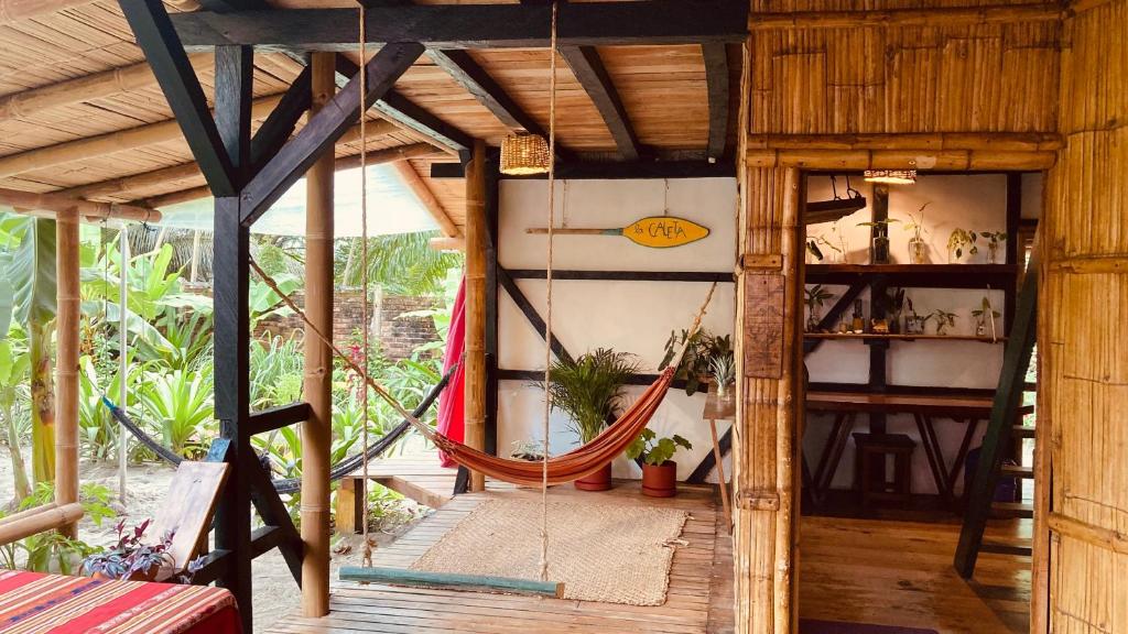 a room with a hammock in a house at La Caleta House in Mompiche
