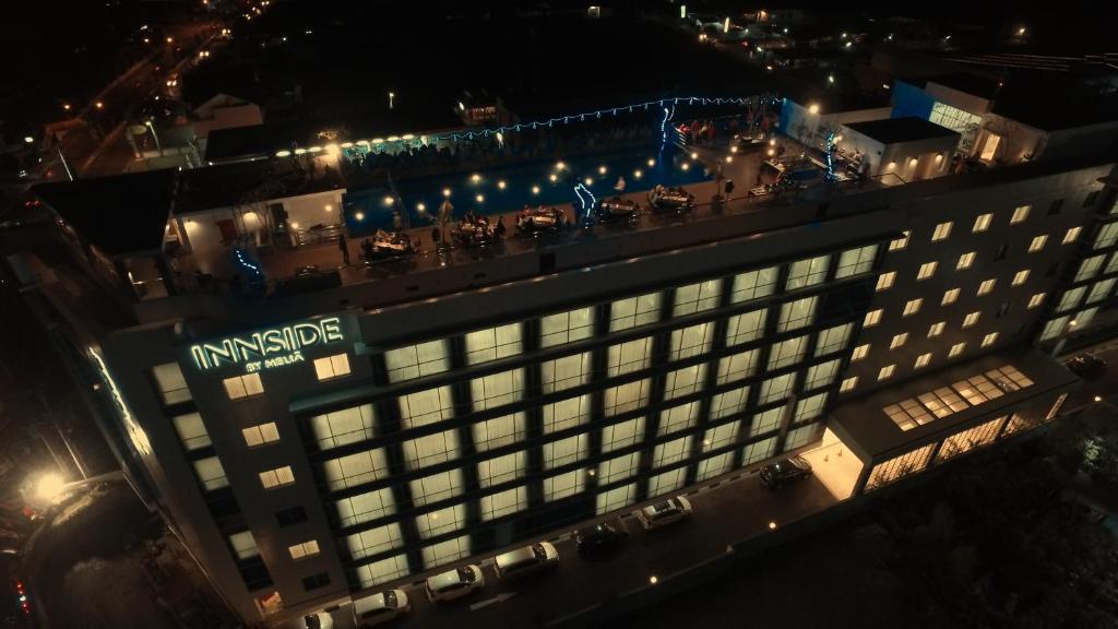 a large building with a sign on it at night at INNSiDE by Meliá Yogyakarta in Yogyakarta