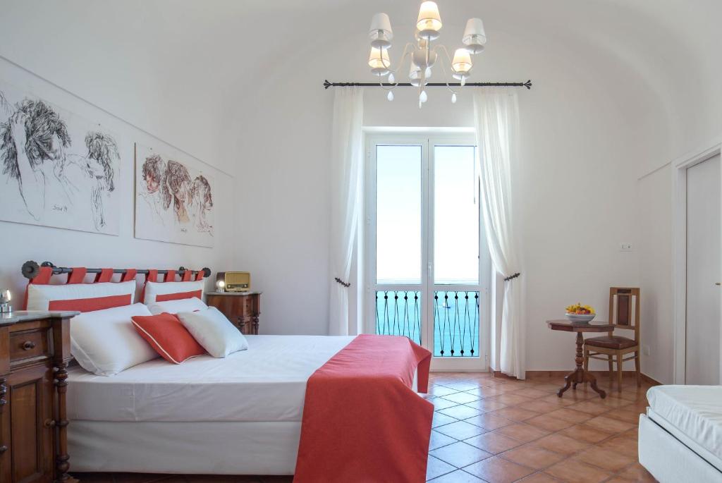 a bedroom with a large bed with red and white pillows at Starhost - CASA BETTINA enchanting seaview in Vietri sul Mare