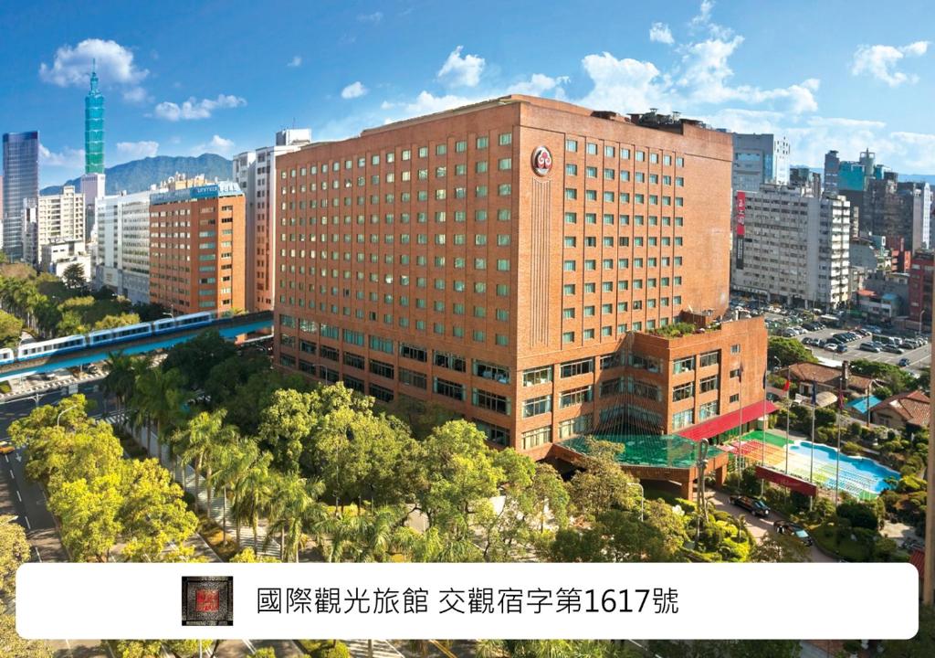 a tall building with a clock on it in a city at The Howard Plaza Hotel Taipei in Taipei