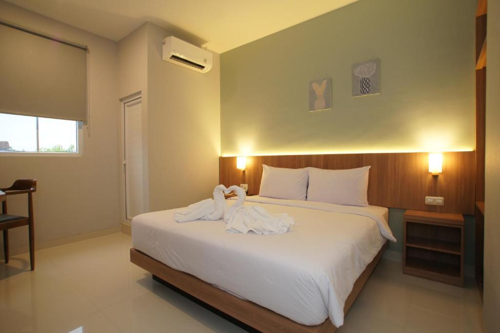 a bedroom with a large bed with towels on it at Hexton Hotel Lampung in Tanjungkarang