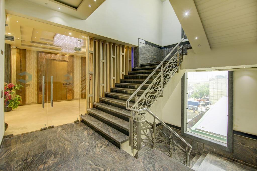a spiral staircase in a building with a window at Super Townhouse Oak Hotel C Pearls in New Delhi