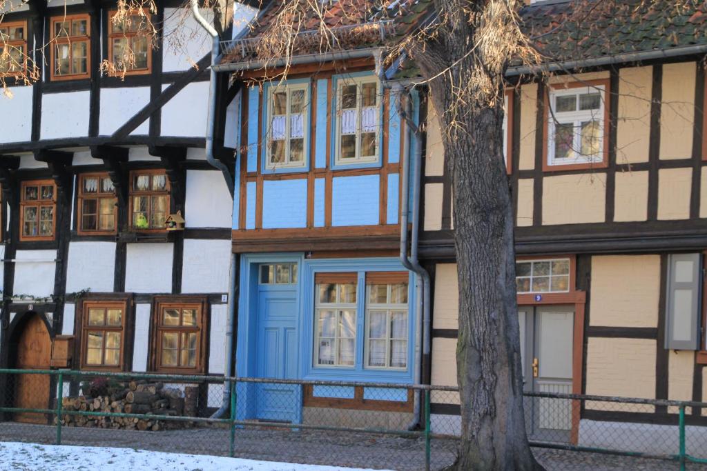 ein Gebäude mit einer blauen Tür und einem Baum in der Unterkunft Blaues Häuschen in Quedlinburg