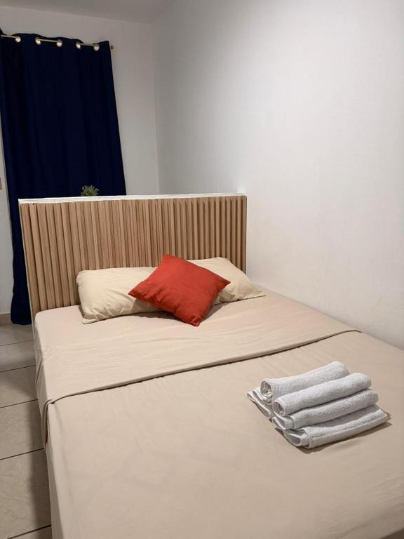 a bed with a red pillow and towels on it at Marena paradise, loft escondido,wifi,piscina12 in La Libertad