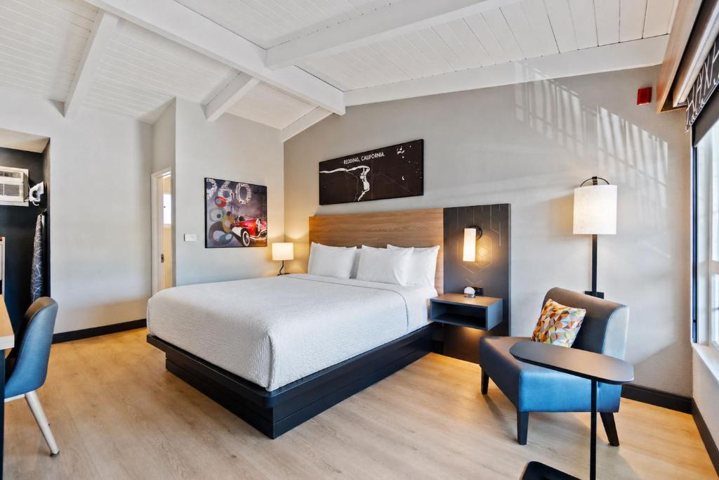 a hotel room with a bed and a chair at Thunderbird Lodge in Redding