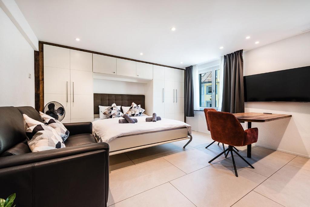 a bedroom with a bed and a couch and a table at CITY-APARTMENT's in Winterthur