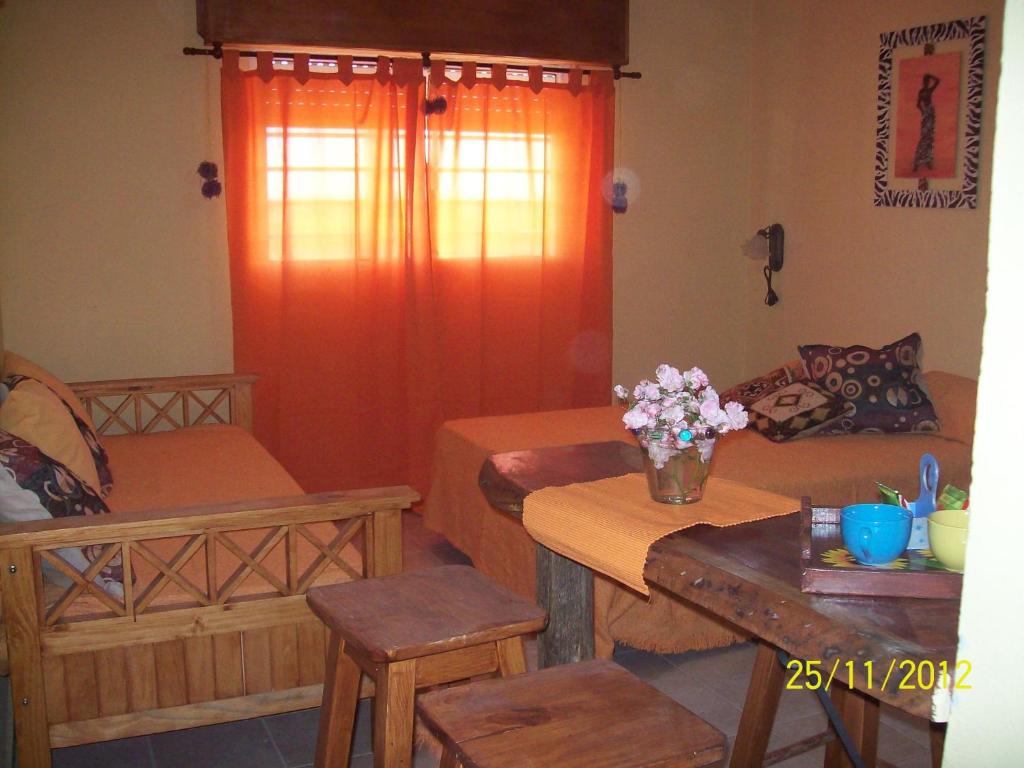 una habitación con 2 camas y una mesa con flores. en Posada De Mar Siguiendo La Luna en La Lucila del Mar