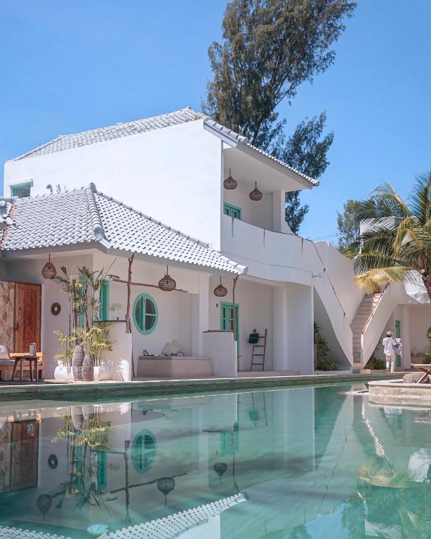 a house with a swimming pool in front of it at Quma Boutique Hotel - Adults Only in Gili Trawangan