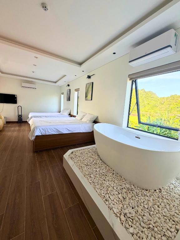a large bathroom with a tub and two beds at Wind Village in Hà Lời