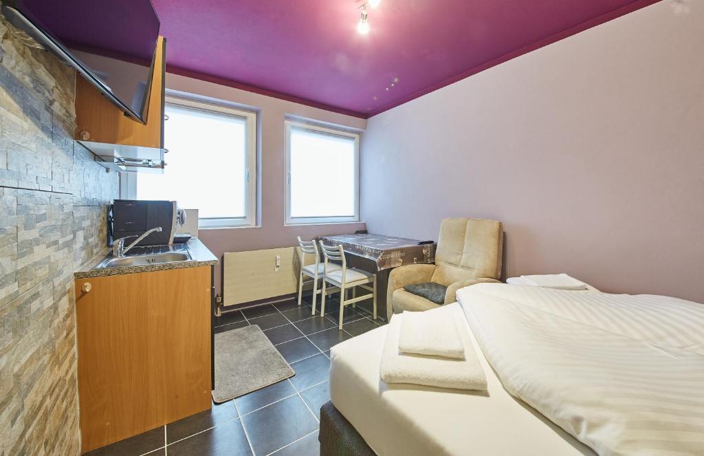 ザールバッハ・ヒンターグレムにあるAppartement Snowflakeのベッドルーム1室(ベッド1台付)、キッチン、デスクが備わります。