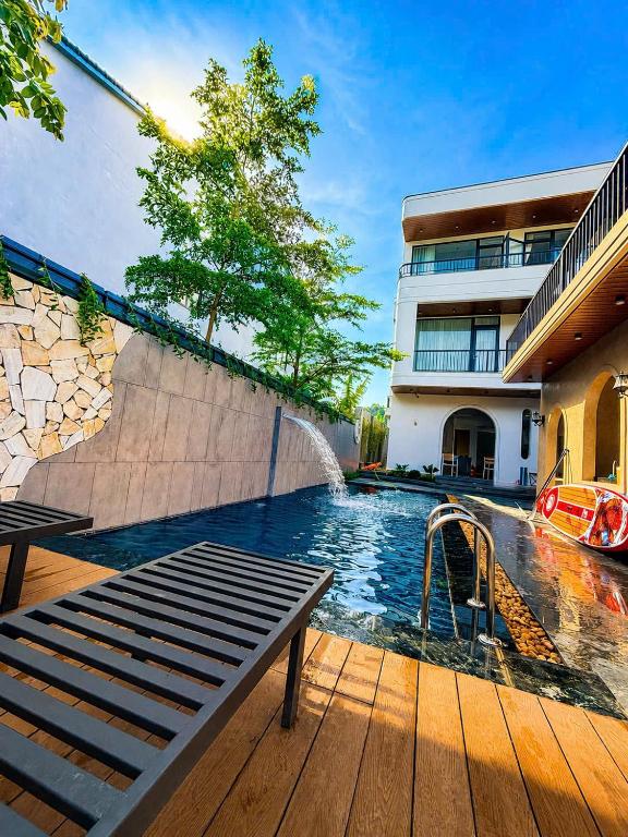 a swimming pool with a bench next to a building at Baram Villas Phong Nha in Hà Lời