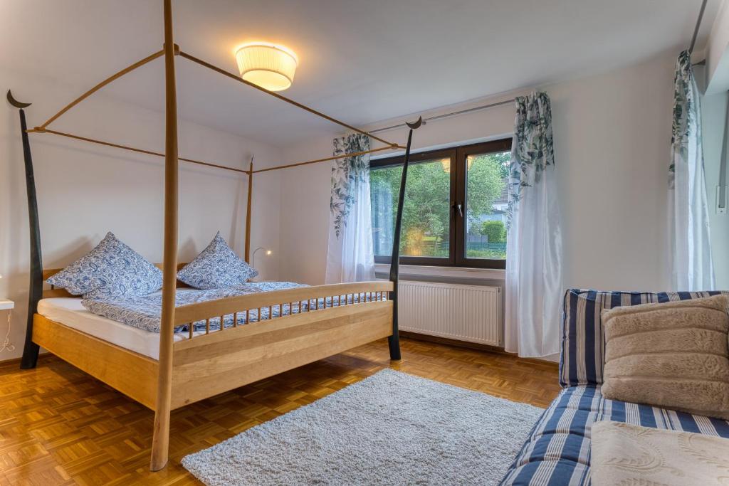 a bedroom with a four poster bed and a window at Nanas-Auszeit in Rothenbuch