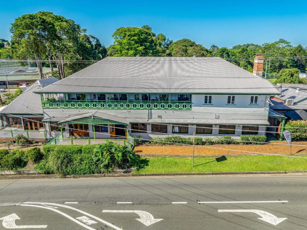 ein weißes Gebäude mit Dach an der Straßenseite in der Unterkunft Maleny Hotel in Maleny