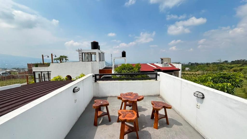 a pair of stools on the balcony of a house at Villa Alibaba D3 in Batu