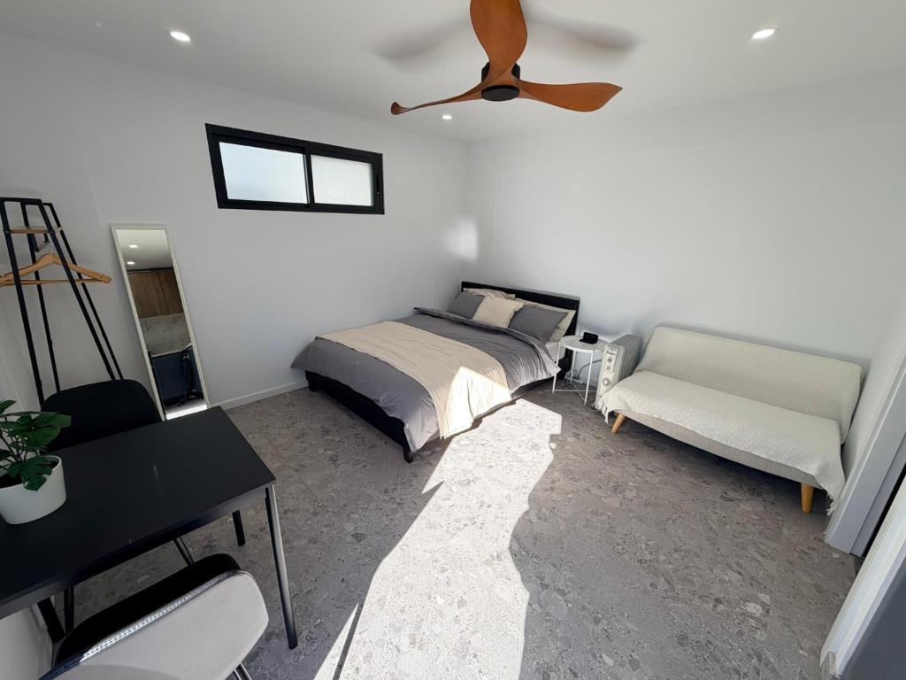 a bedroom with a bed and a ceiling fan at Sydney Studio with Private Bathroom & Kitchen in Revesby