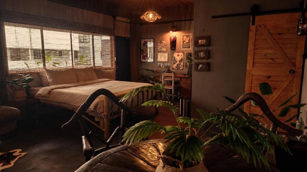 a bedroom with a bed and a potted plant at Cinematique Boutique Cinema Hotel in Bangkok