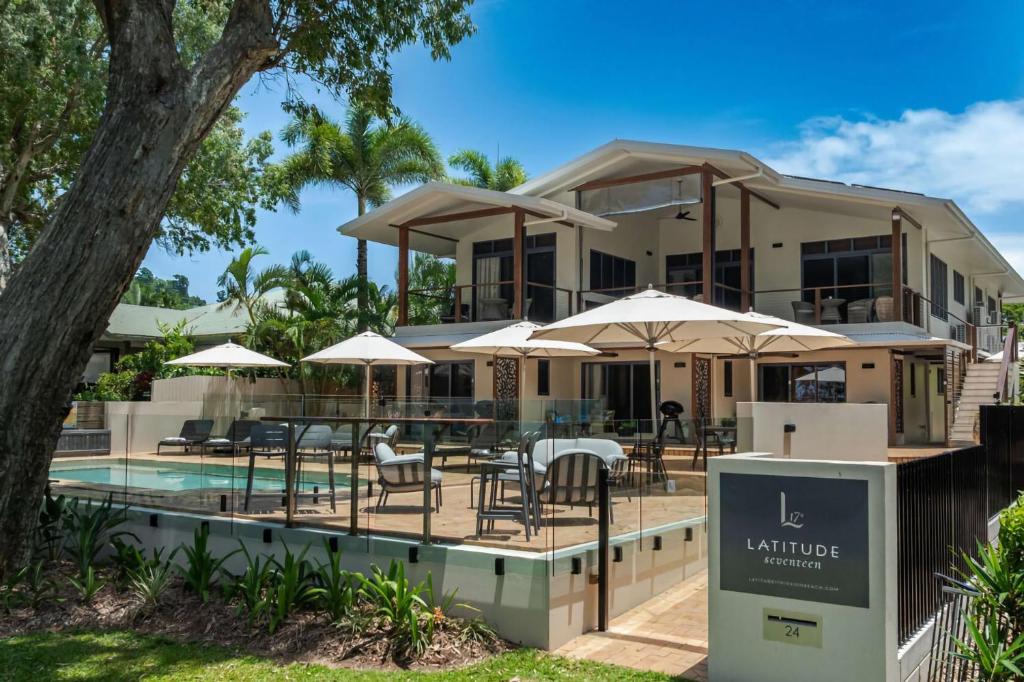 a resort with a pool and tables and umbrellas at Latitude 17 Suite 2 in South Mission Beach
