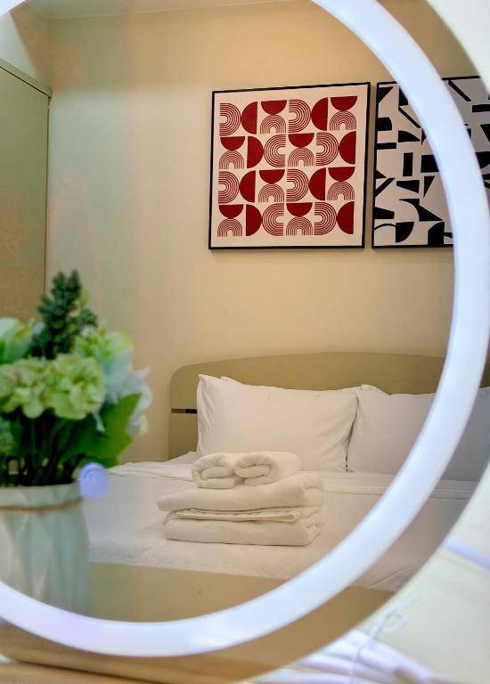 a mirror with towels on a bed in a room at Huko House in Ho Chi Minh City
