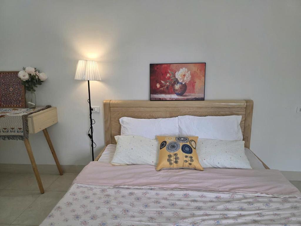 a bedroom with a bed with a painting on the wall at Lishome My Khe Beach Apartment - An Thuong in Danang