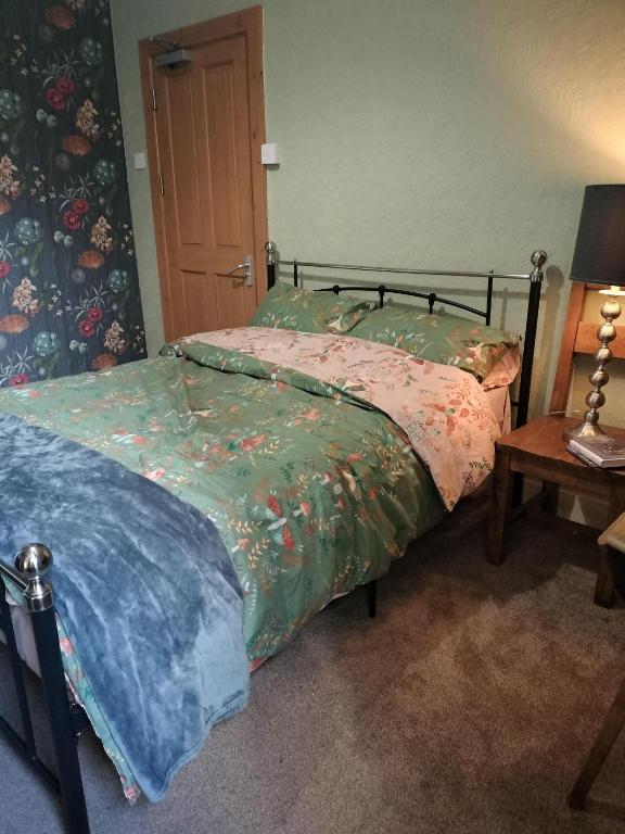 a bedroom with a bed and a table with a lamp at Uplands Room in Swansea
