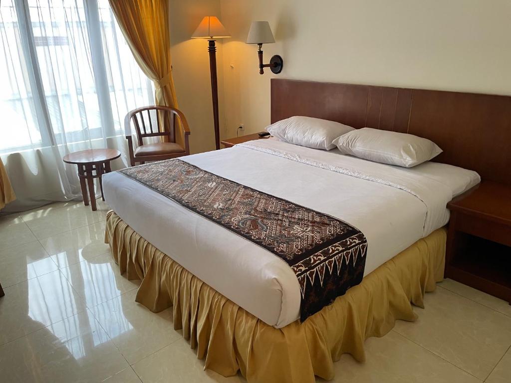 a bedroom with a large bed in a hotel room at Baron Indah Hotel Solo in Grogol