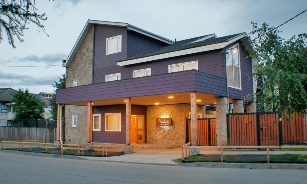 a house with a purple roof on a street at Madero Aysen ApartHotel in Coihaique