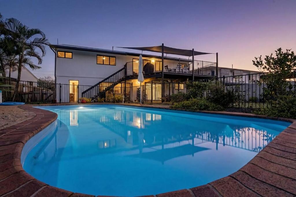a large swimming pool in front of a house at Serenity Sands in South Mission Beach
