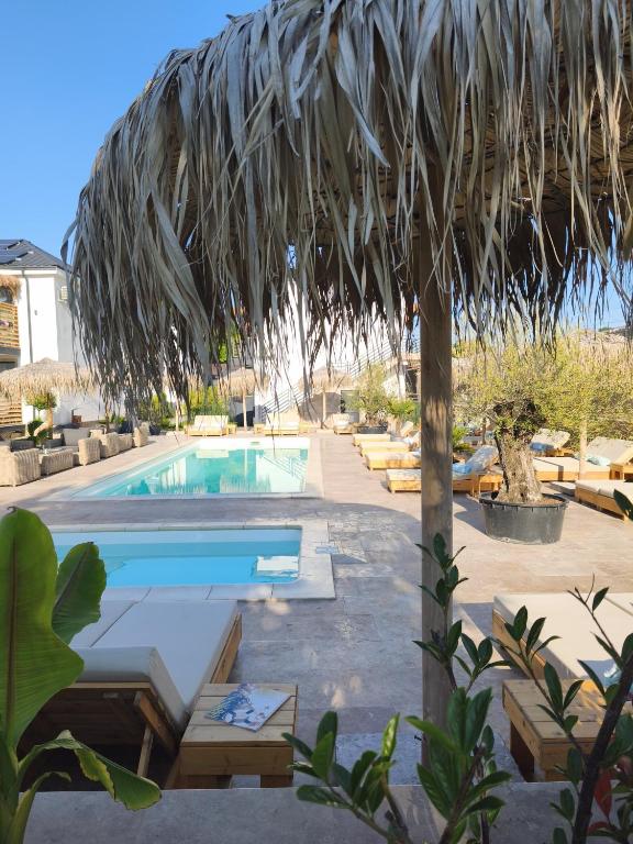 a swimming pool with a straw umbrella and a resort at Complex Sea Star 2Mai in 2 Mai