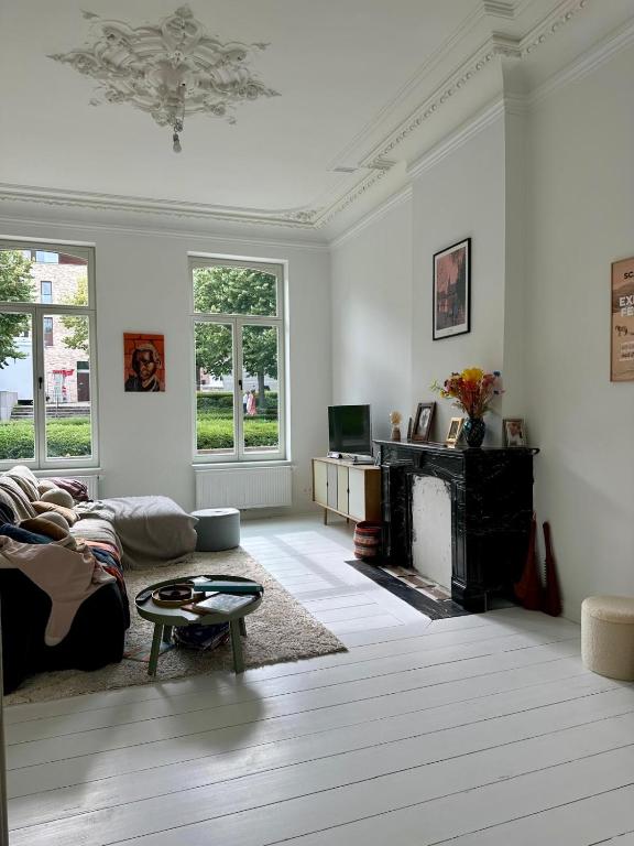 a living room with a couch and a fireplace at Elegant Manor House in Tongeren