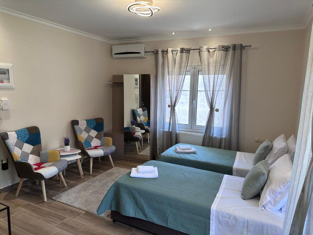 a hotel room with two beds and chairs at MoSta Sunset in Litochoro