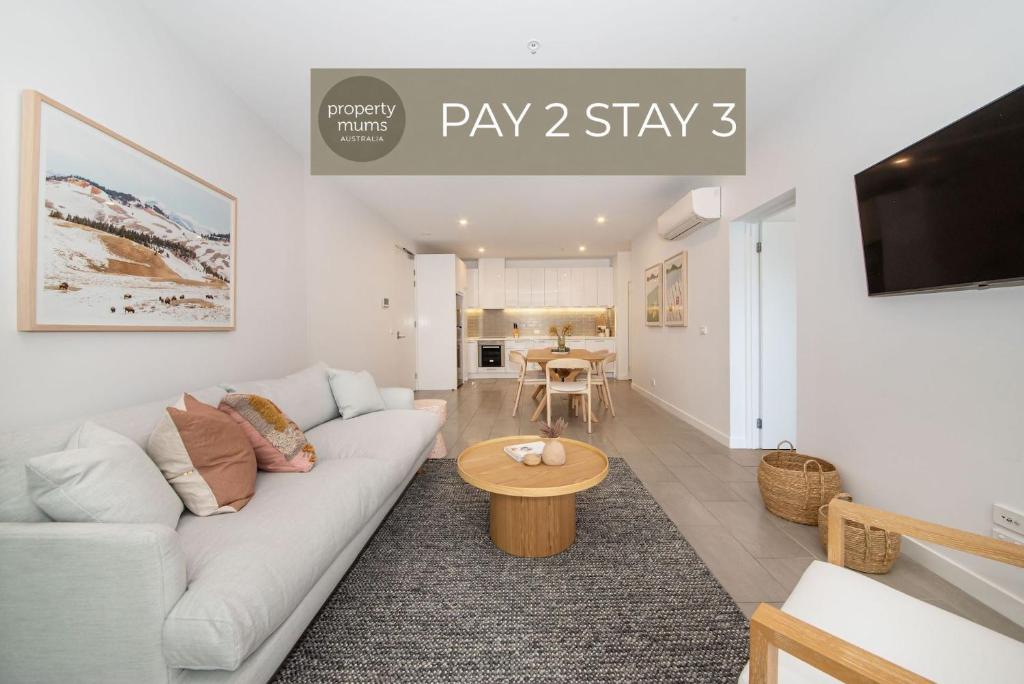 a living room with a white couch and a table at Apartment Living on the Beach in Rosebud